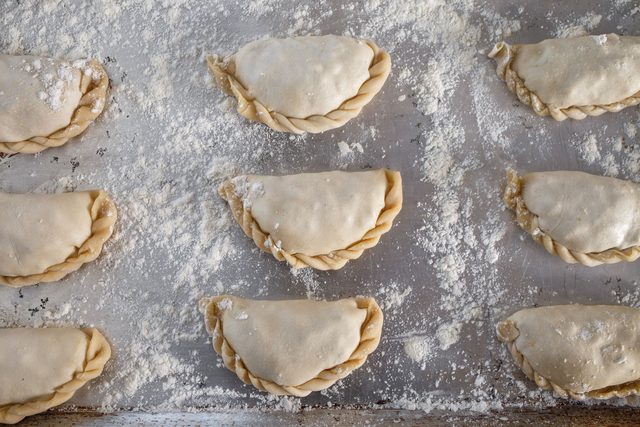 Empanadas crudas sobre bandeja enharinada